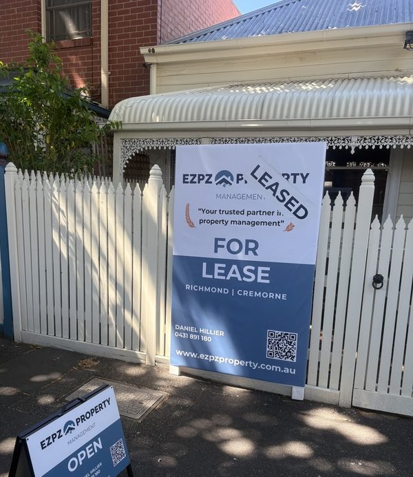 An EZPZ Property Management 'For Lease' board with a 'LEASED' banner across it, outside a Richmond cottage.